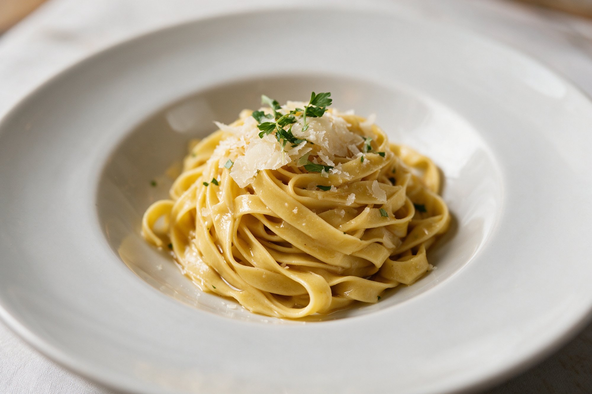 Tagliatelle fresca con salsa brillante y parmesano en plato cálido